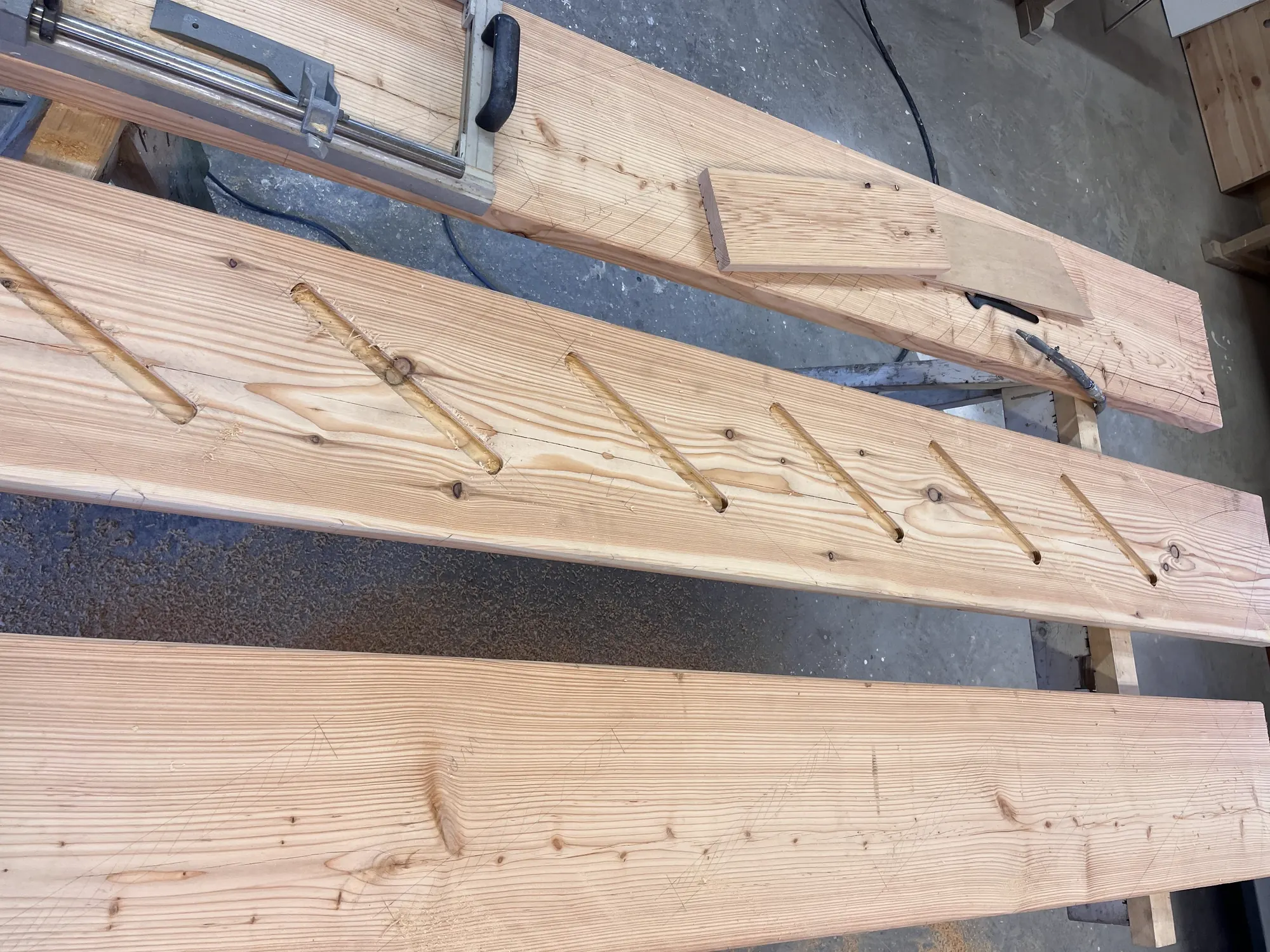 Angerissener Holzbalken mit ausgearbeiteten Zapfen in der Werkstatt