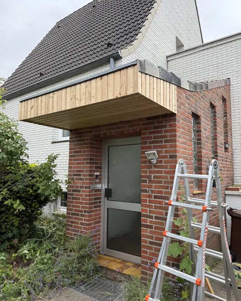 Vordach während der Montage, die Leiter steht noch am Klinkermauerwerk