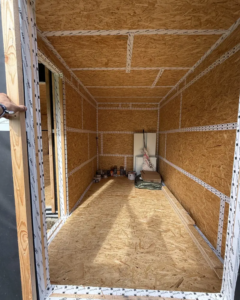 Blick durch die Türöffnung in den fertig beplankten Innenraum des Gartenhauses