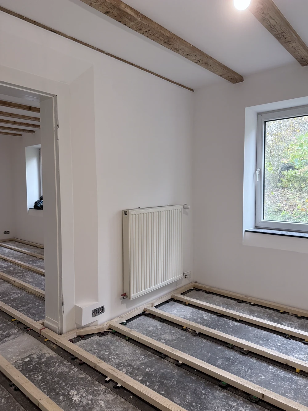 Detailansicht der neuen Balkenunterkonstruktion vor frisch verputzter Wand