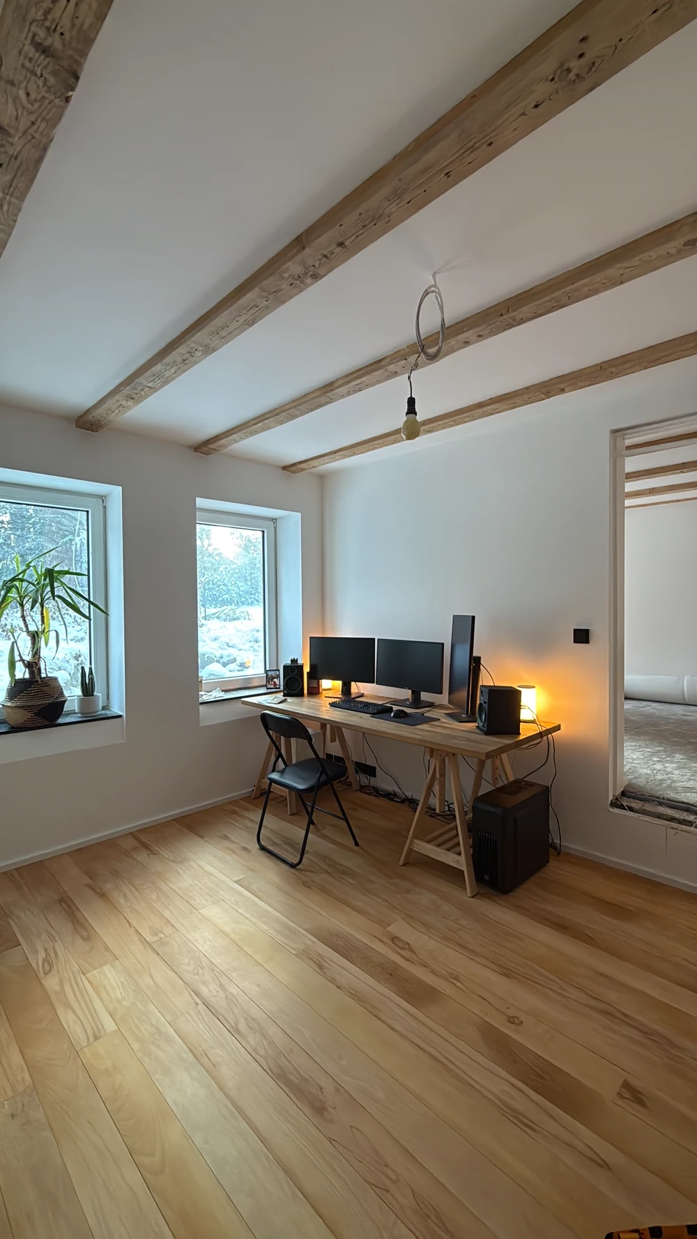 Fertiger Wohnraum mit neu verlegtem Holzdielenboden und Fensterfront